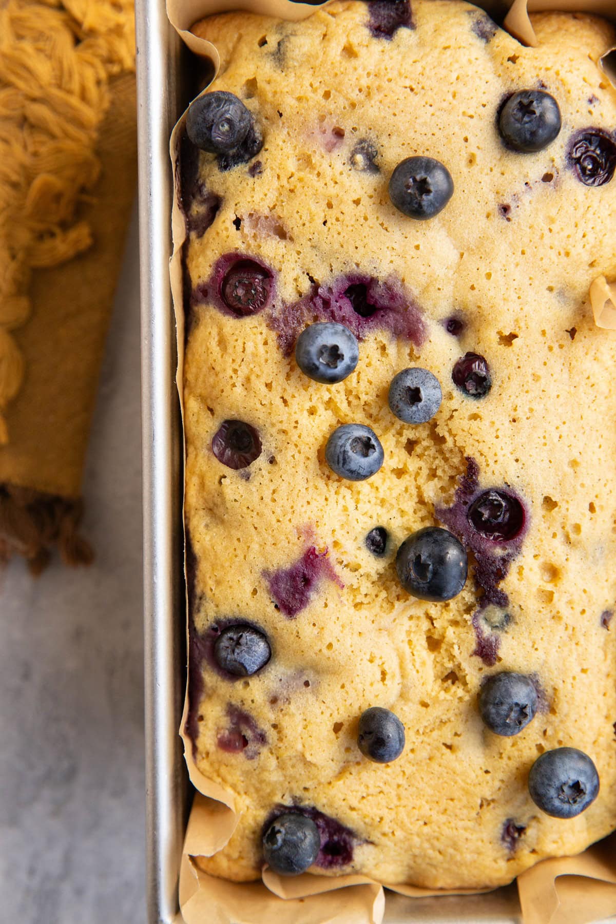 Loaf pan of blueberry bread, fresh out of the oven, ready to eat.