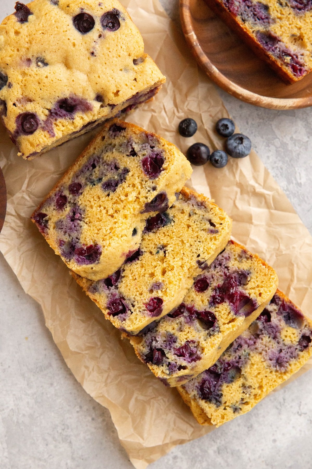 Grain-free blueberry bread sliced on a sheet of parchment paper.