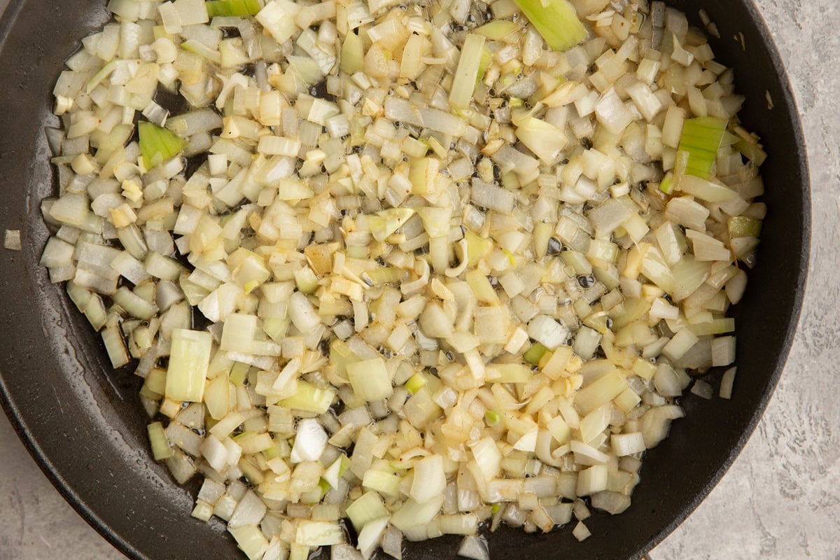 Skillet with chopped onion sauteeing.