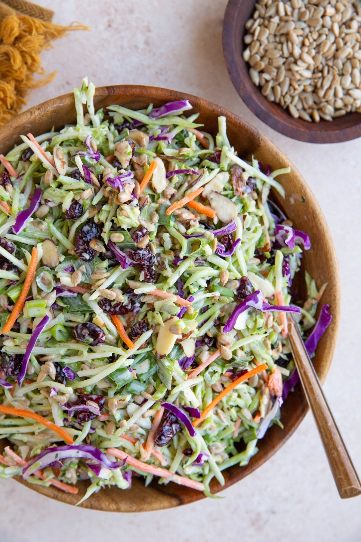Broccoli coleslaw in a large wooden bowl, ready to serve.