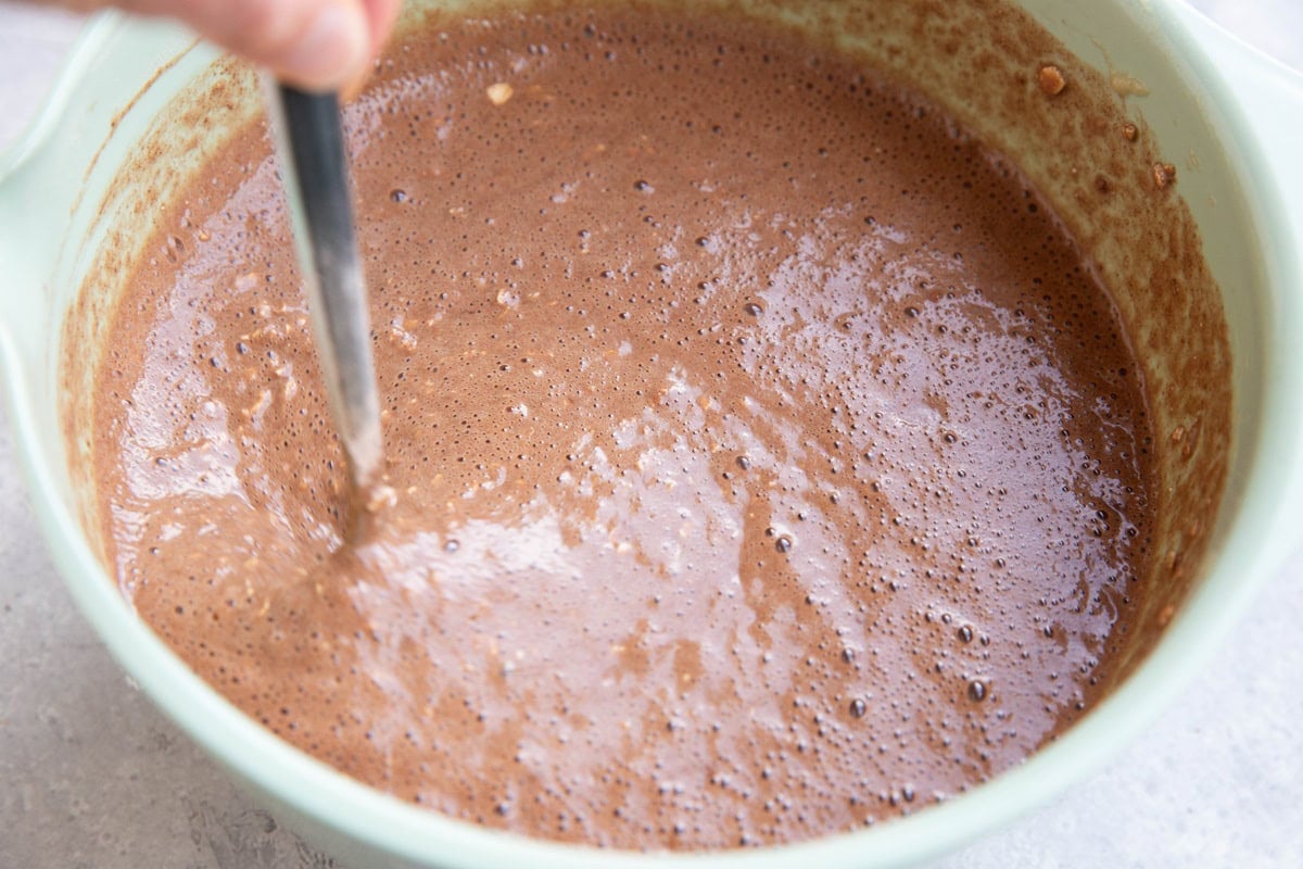 Stirring oatmeal mixture in a mixing bowl.