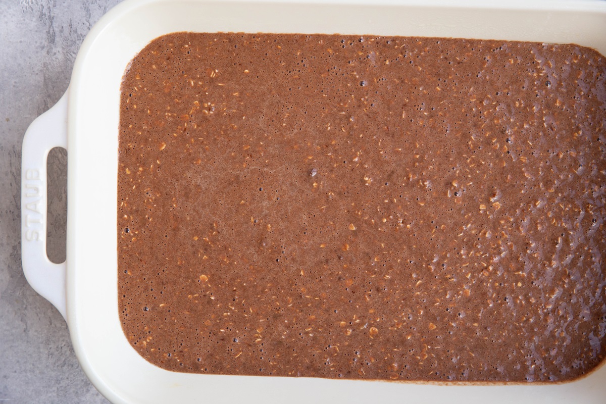 Chocolate baked oatmeal mixture in a casserole dish, ready to go into the oven.