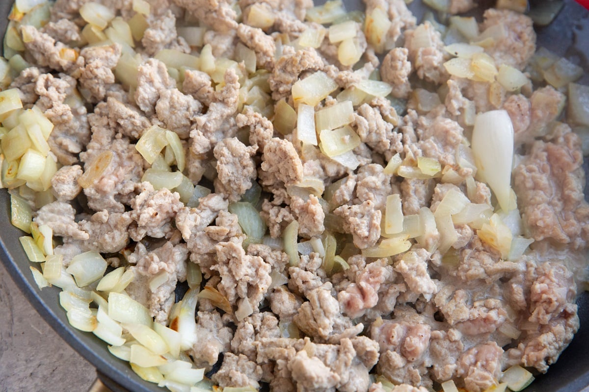Onion and ground turkey cooking in a skillet.