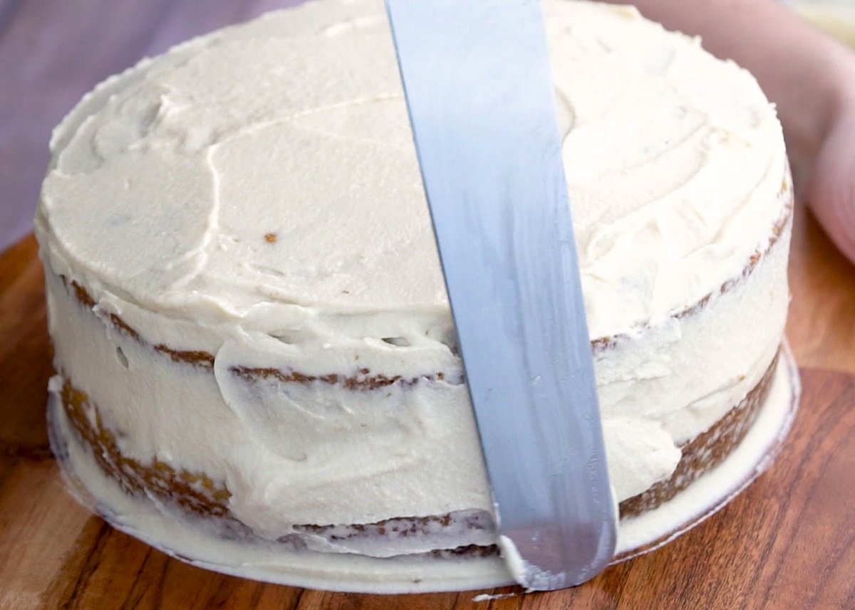 Spreading cream cheese frosting over the cake.