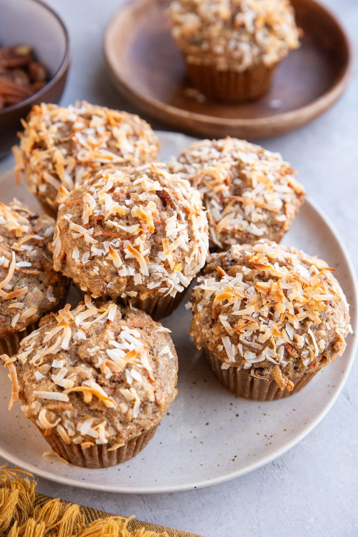 Plate of healthy carrot cake muffins on a plate with a wooden plate in the background.