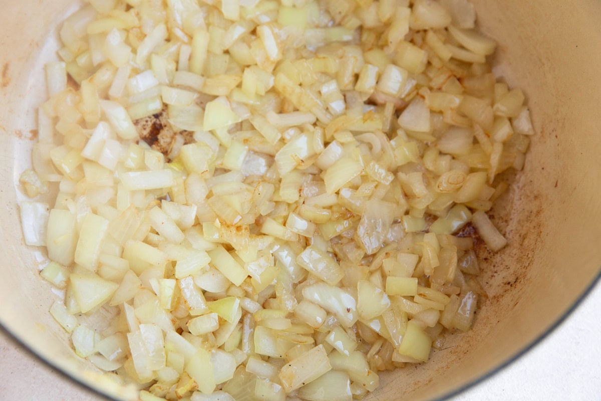 Onions sautéing in a large pot.