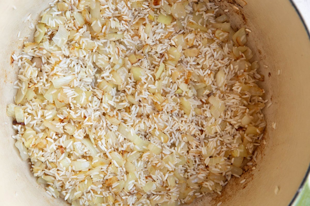 Pot of onion, garlic, and rice cooking.