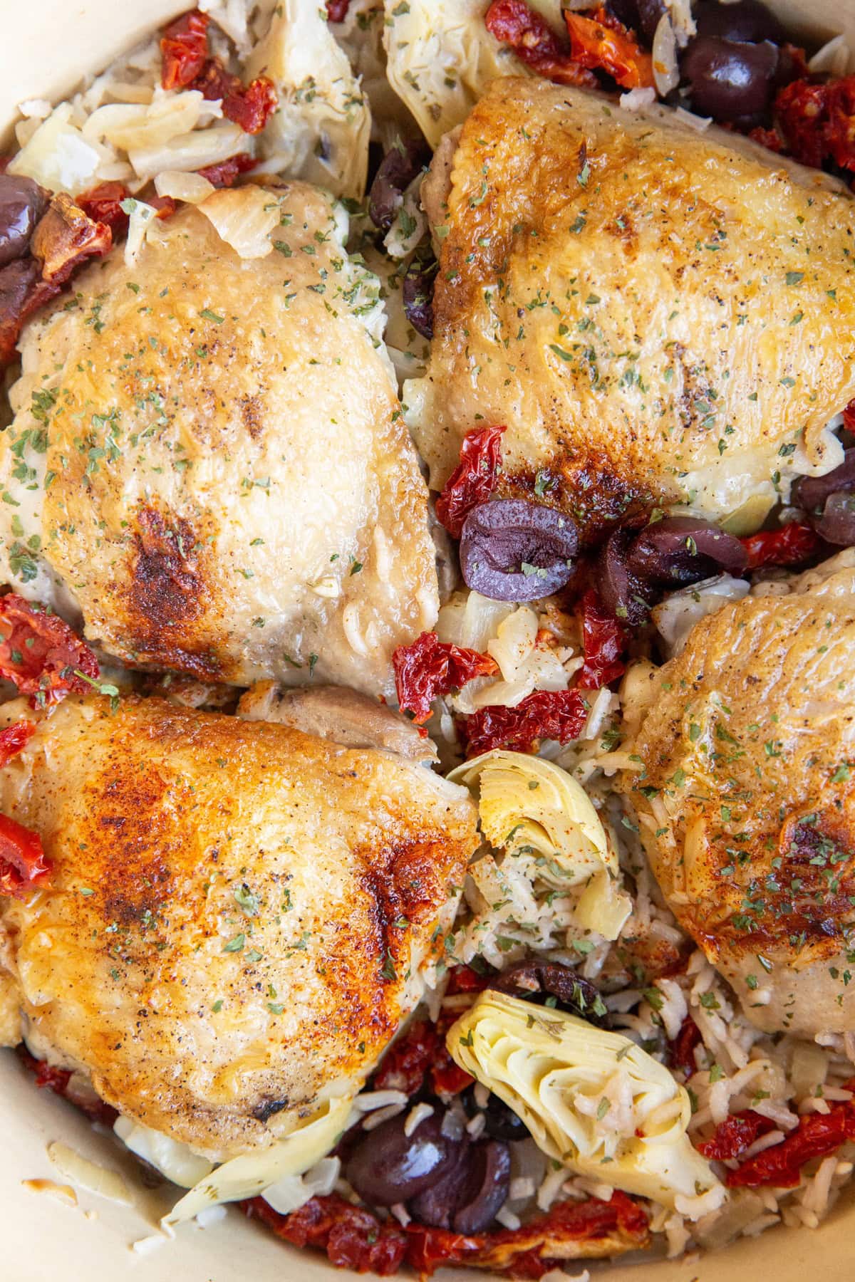 Large pot full of chicken thighs with flavorful Mediterranean Rice.