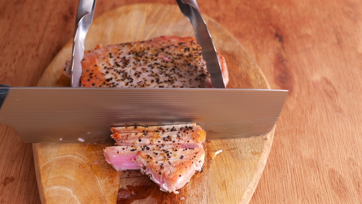 Knife slicing the ahi steak into slices.