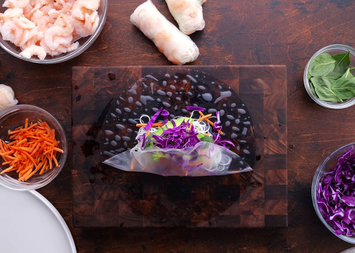 Folding the bottom of the rice paper up over the ingredients in the center