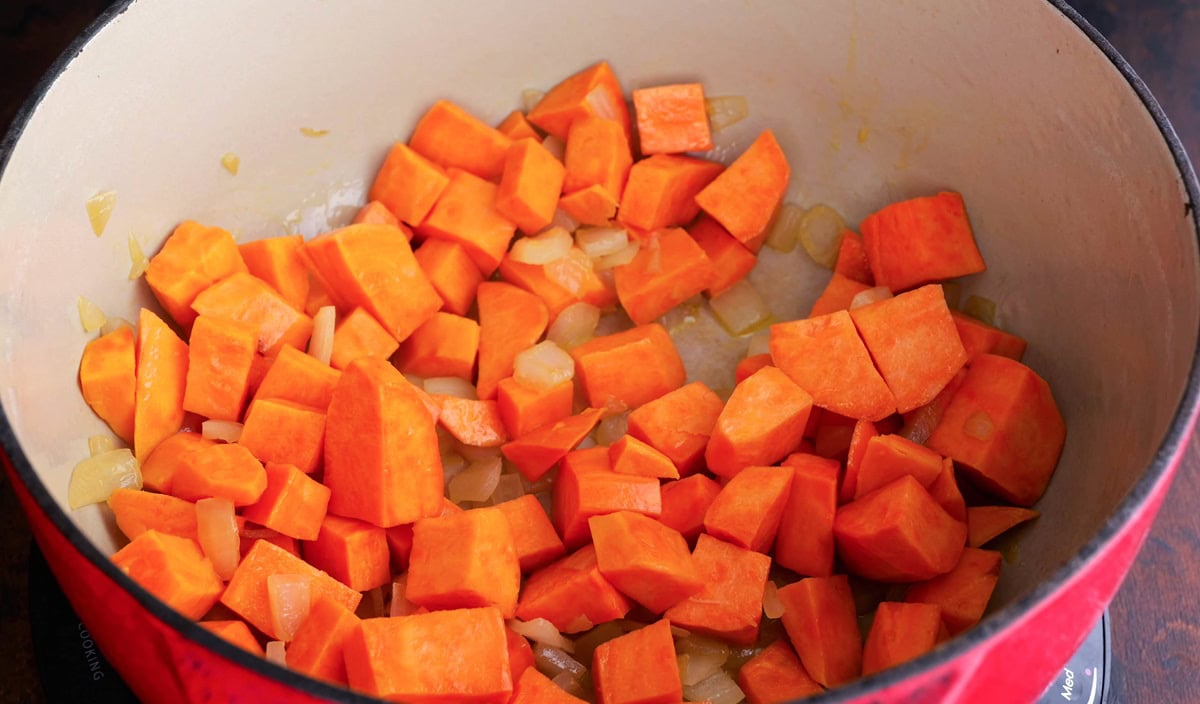 Onion and sweet potato cooking in a large soup pot