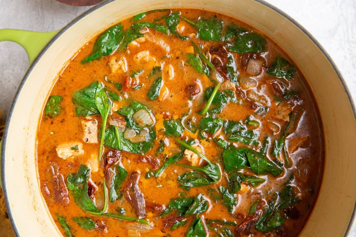 Large pot of chicken Tuscan soup, ready to serve.