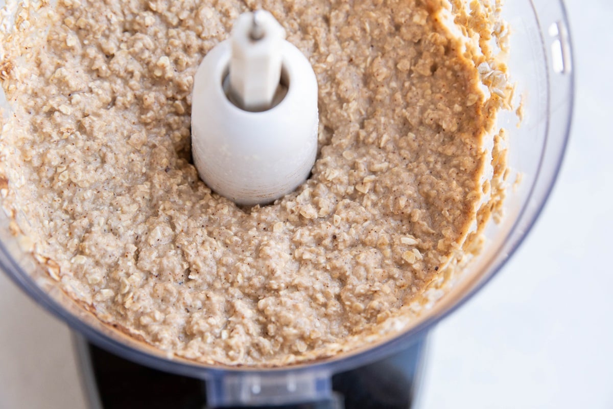 Food processor with applesauce oatmeal cookie batter inside.