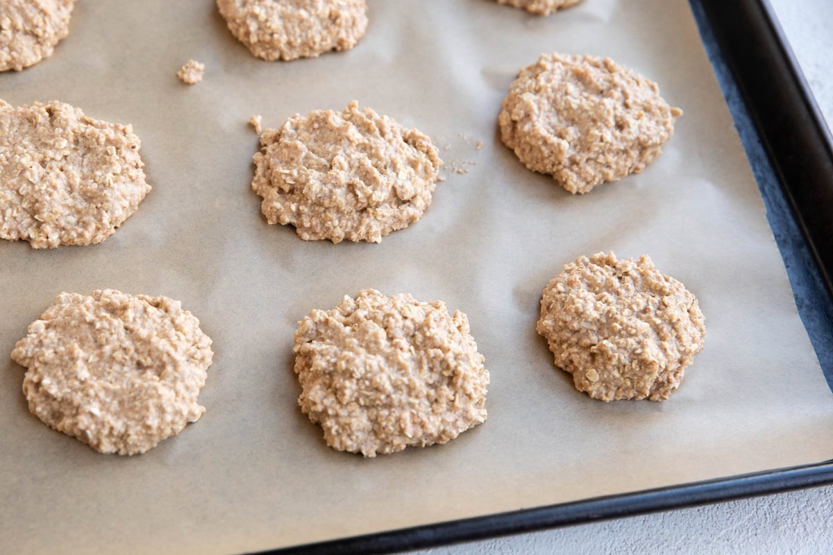 Applesauce cookie dough on a large baking sheet, ready to go into the oven.