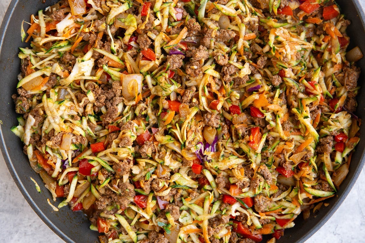 ground beef and vegetables cooking in a large skillet.