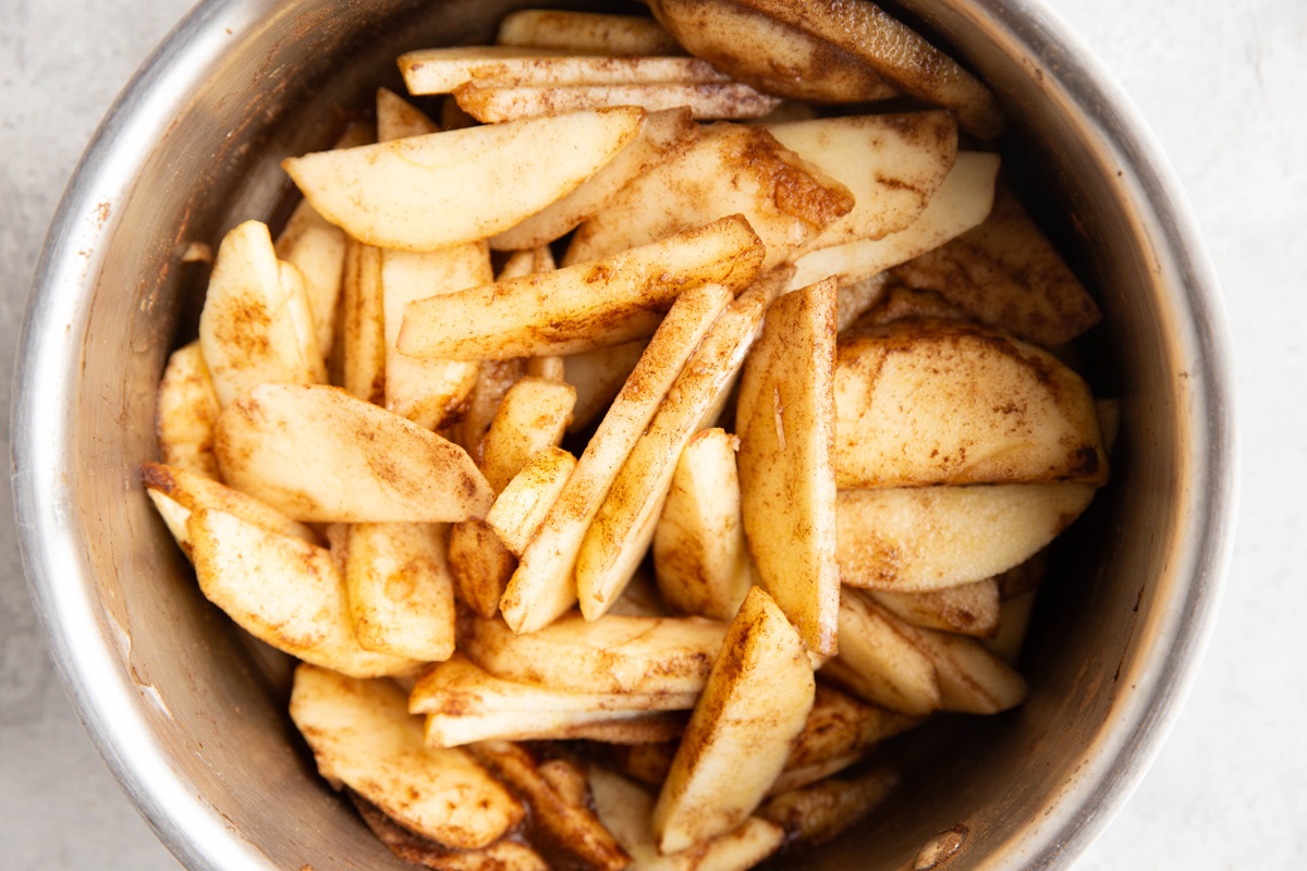 Apple slices in a saucepan, ready to cook and soften.