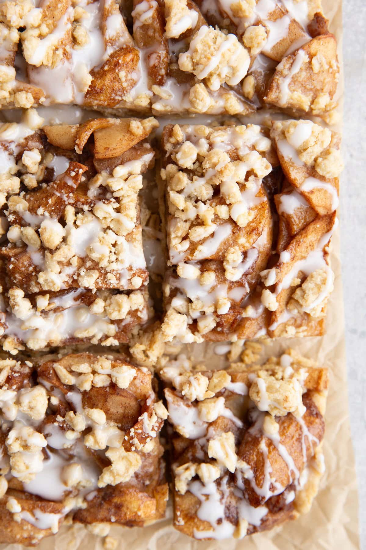 Slices of apple crumb bars on a sheet of parchment paper.