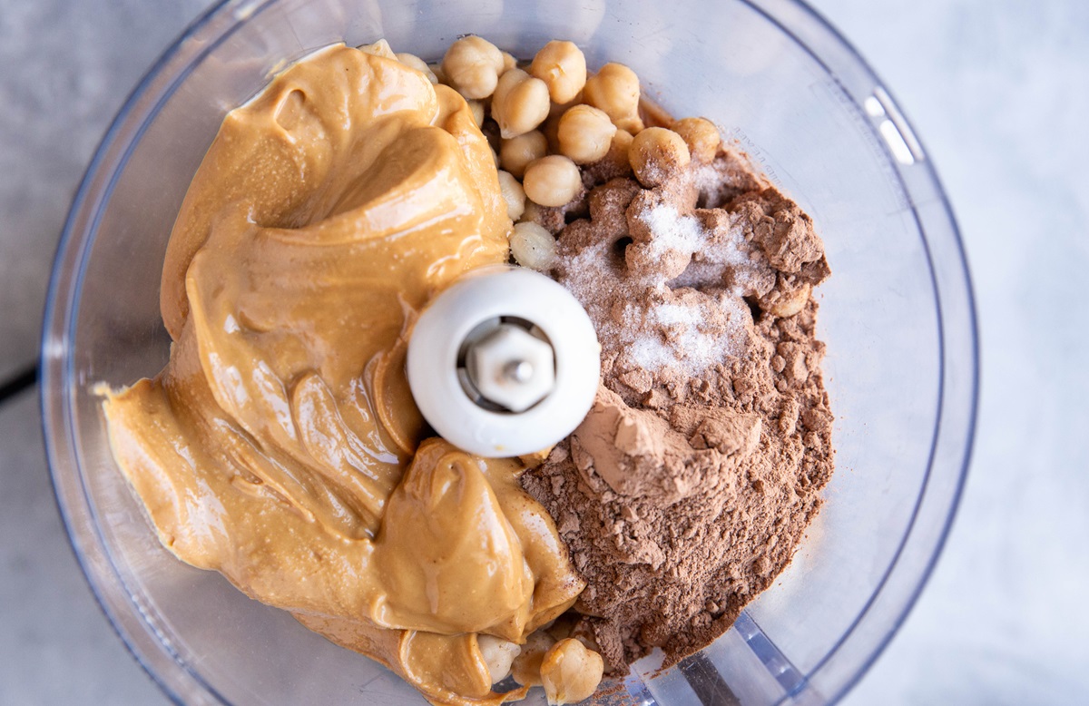 Ingredients for peanut butter chocolate garbanzo bean cookies in a food processor.