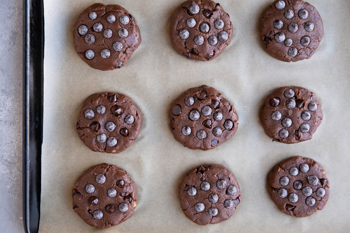 baking sheet lined with parchment paper with chickpea cookie dough on top, ready to be baked.