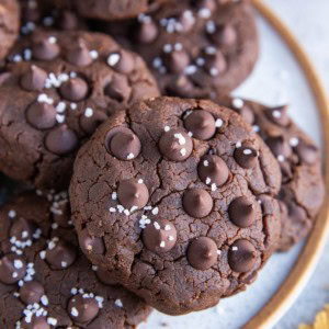 Plate with chocolate chickpea cookies on top, close up and sprinkled with coarse sea salt.