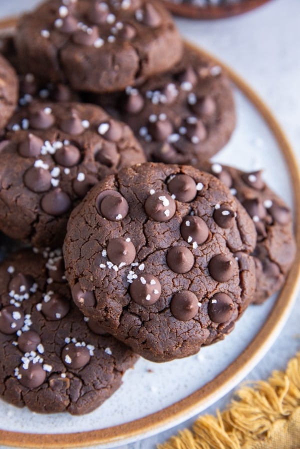 Plate with chocolate chickpea cookies on top, close up and sprinkled with coarse sea salt.