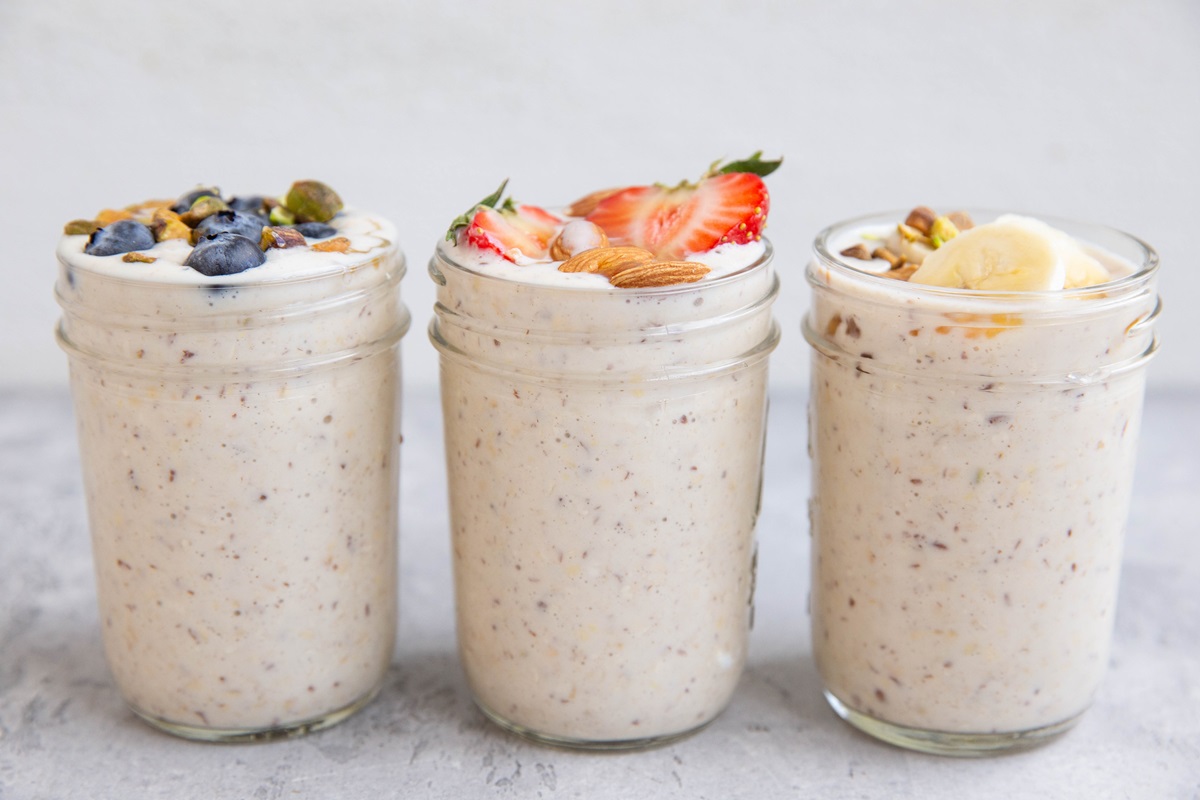 Three jars of overnight oats with fresh fruit on top.