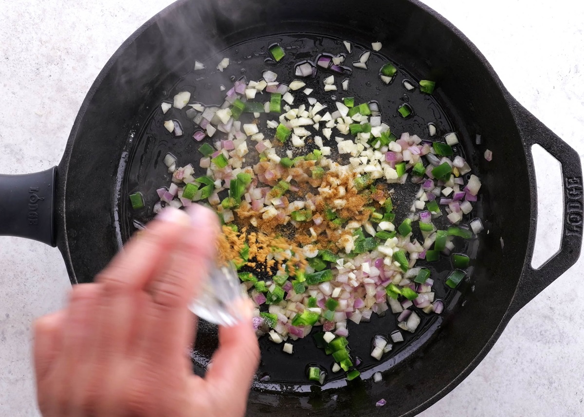 Onion, garlic, jalapeno, and cumin in a skillet, sautéing.