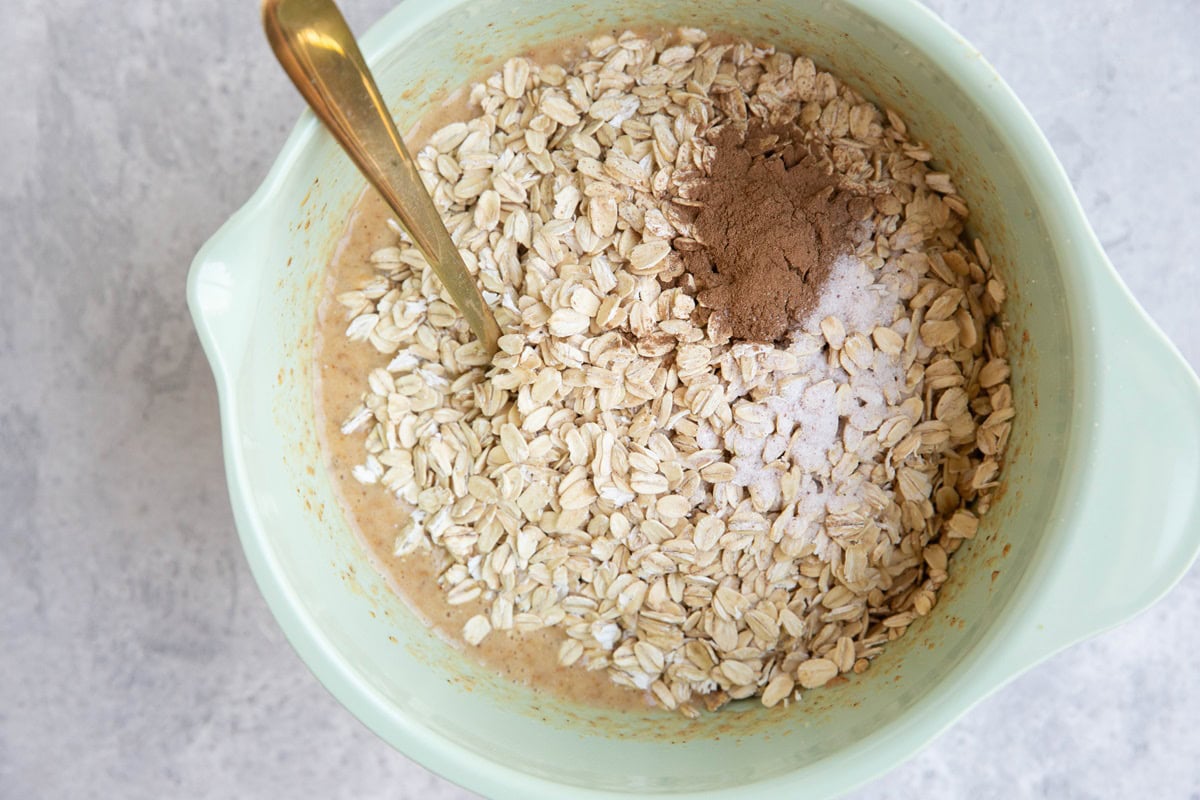 Wet ingredients and oats in a mixing bowl to make strawberry banana oat muffin cups