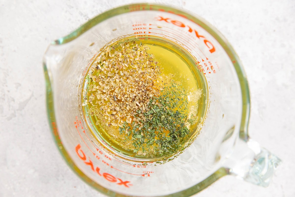 Italian salad dressing ingredients in a measuring cup.