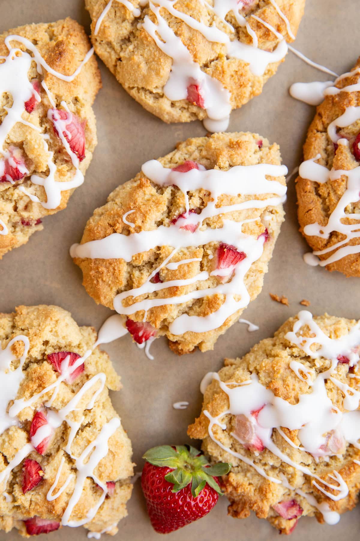 Baking sheet with almond flour scones, drizzled with glaze.