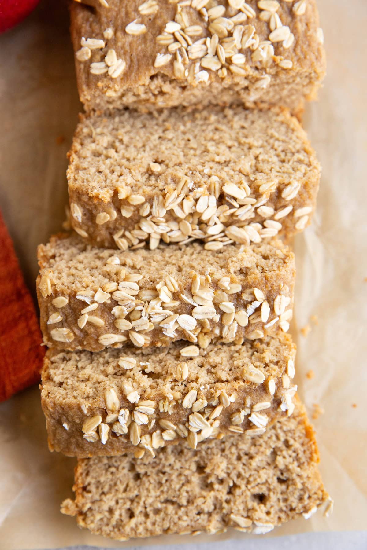 Loaf of applesauce bread on a sheet of parchment paper, cut into slices.