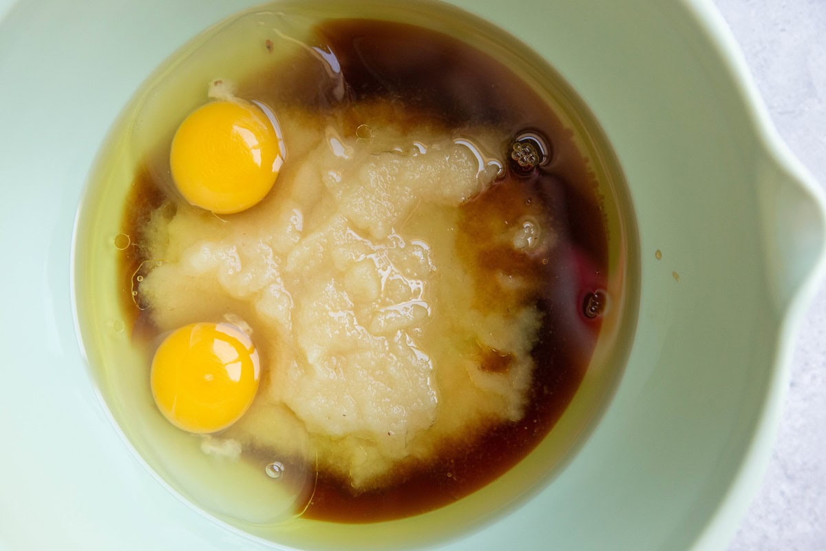 Wet ingredients for applesauce bread in a mixing bowl.