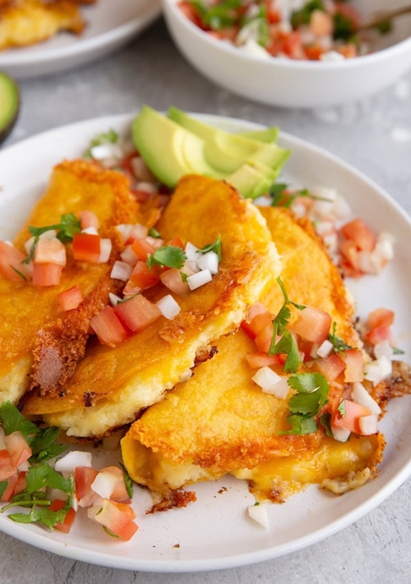 Plate of potato tacos with pico de gallo on top
