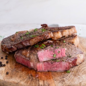 Ribeye steaks on a wooden cutting board