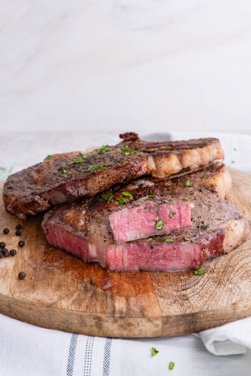 Ribeye steaks on a wooden cutting board