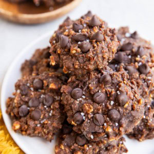White plate with a stack of no-bake cookies on top and a golden napkin to the side.