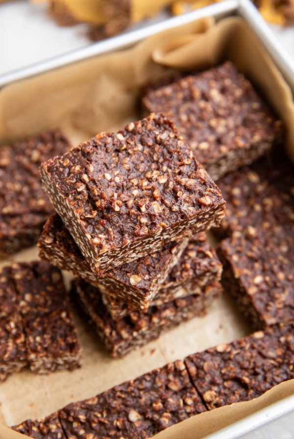 Stack of no-bake cookie bars in a baking dish, ready to eat.