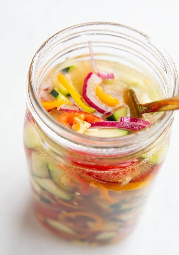 Large jar full of vegetables and vinegar solution to make quick pickled vegetables.
