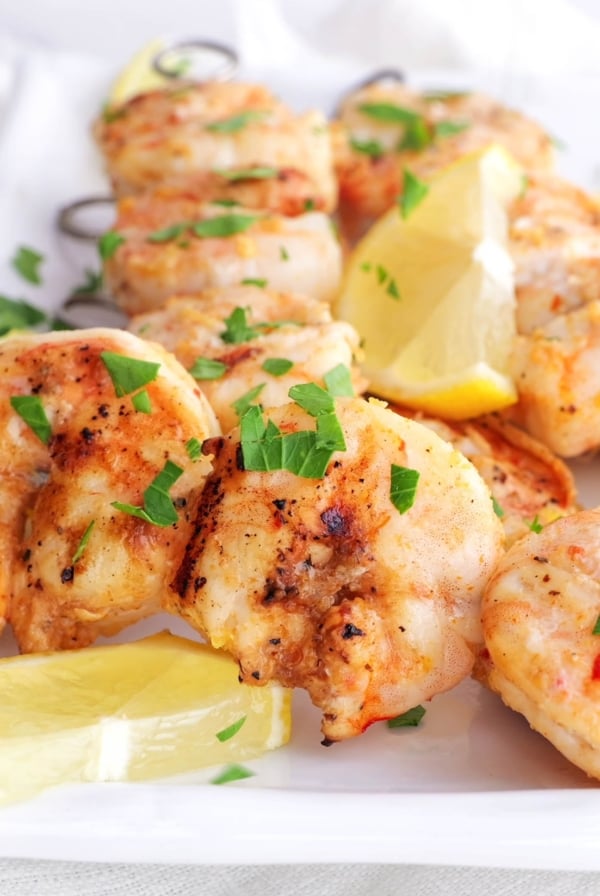 Shrimp skewers sprinkled with fresh parsley, ready to eat.