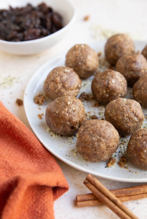 Plate of energy balls with a red napkin and cinnamon sticks to the side.