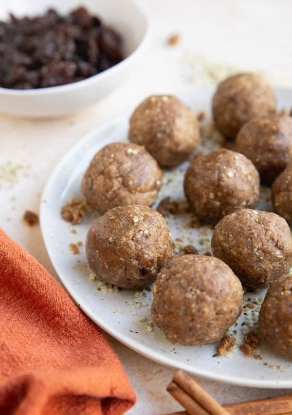 Plate of energy balls with a red napkin and cinnamon sticks to the side.