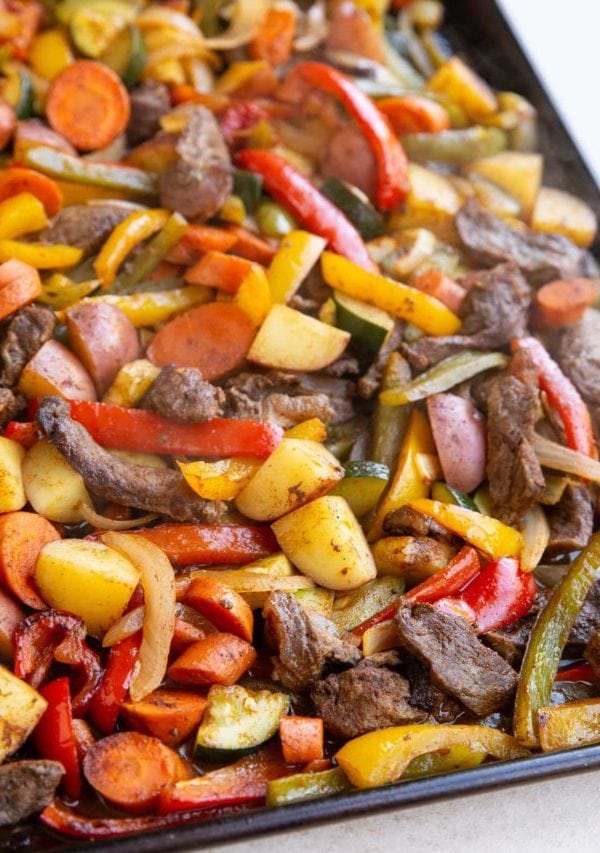 Sheet pan full of cooked steak and vegetables, fresh out of the oven and ready to serve.
