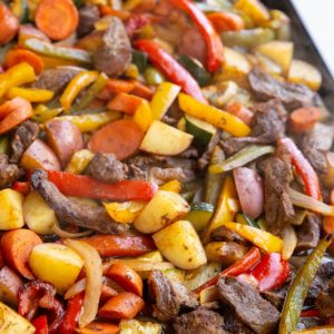 Sheet pan full of cooked steak and vegetables, fresh out of the oven and ready to serve.
