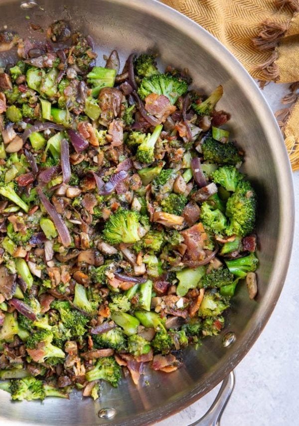 Stainless steel skillet full of sauteed broccoli and mushrooms, ready to eat.