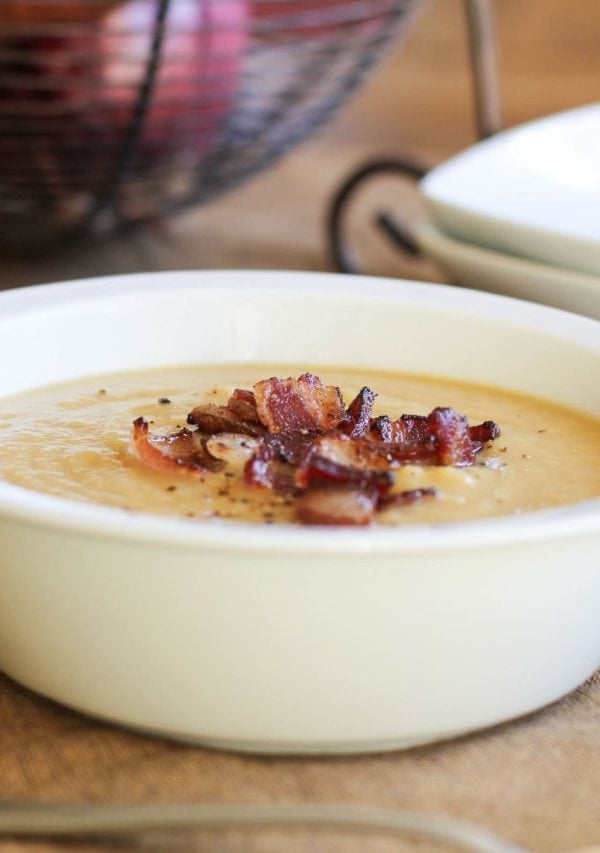 Bowl of potato leek soup with crispy bacon on top