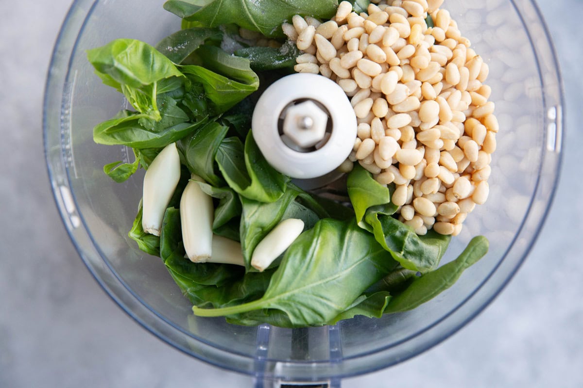 Pesto sauce ingredients in a food processor.