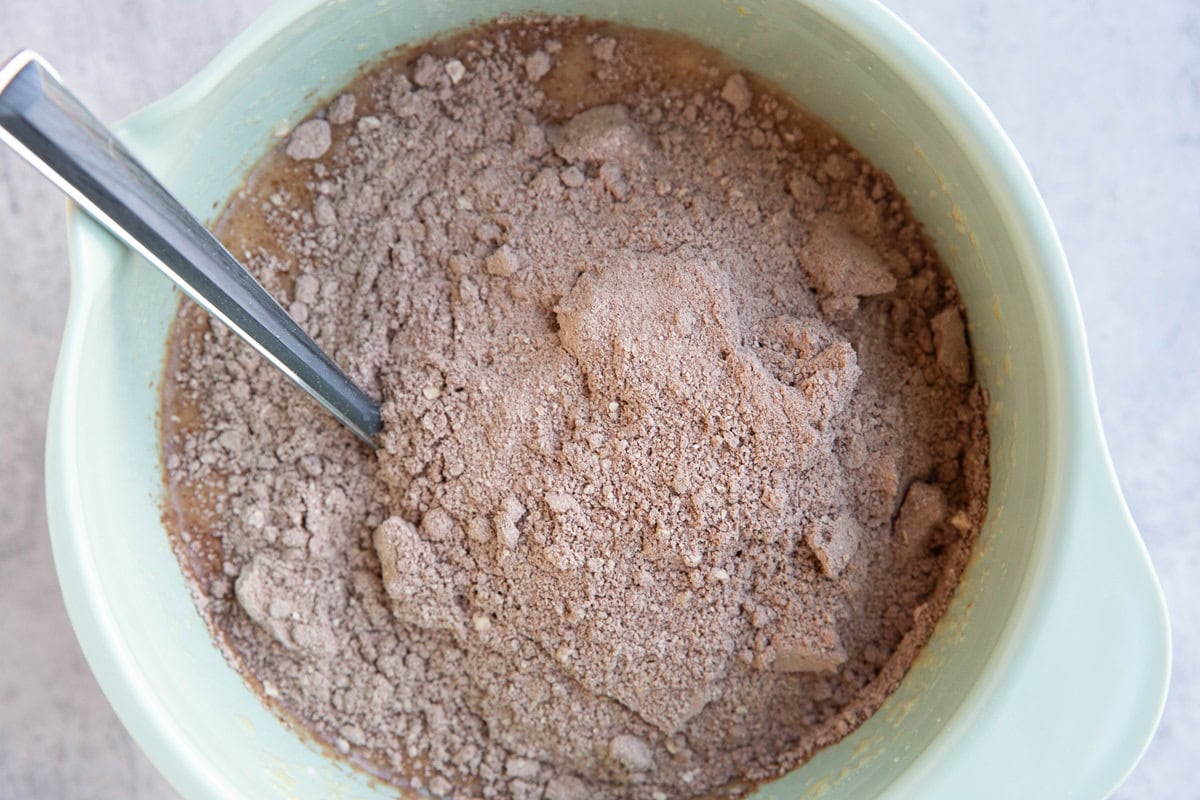 Mixing bowl with wet ingredients mixed together and the dry ingredients on top.