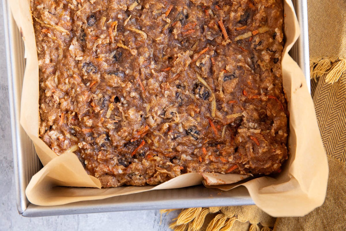 Carrot cake almond flour breakfast bars in a baking dish fresh out of the oven with a napkin to the side.