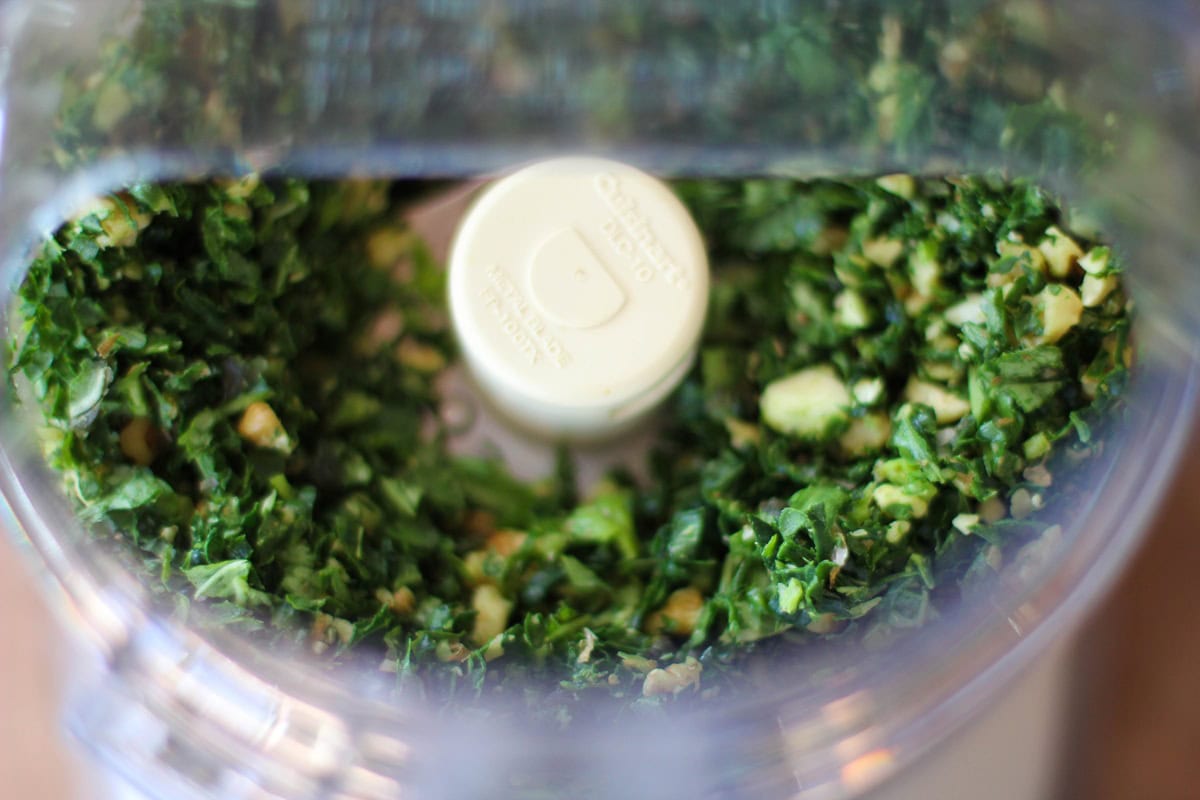 Ingredients for kale pesto sauce in a food processor.