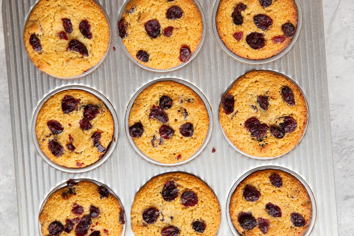 Muffin tray with cranberry orange muffins fresh out of the oven, ready to serve.